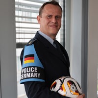 Mika Stalleicken posiert in Uniform mit einem Fußball in der Hand.