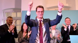 Ministerpräsident Hendrik Wüst ( CDU ) hebt die Arme nach seinem Statement und lässt sich feiern