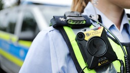 Eine Polizistin führt eine Bodycam vor