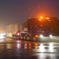 Ein Schwertransporter verlässt im Dunkeln das Forschungszentrum Jülich
