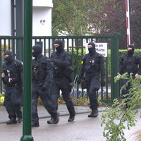 Polizeibeamte mit Sturmhauben laufen durch das Tor der Justizvollzugsanstalt Euskirchen