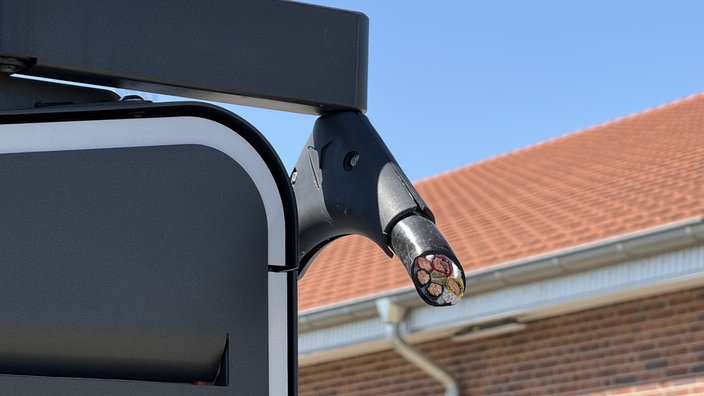 Eine Ladesäule für Elektroautos mit einem abgetrennten Kupferkabel