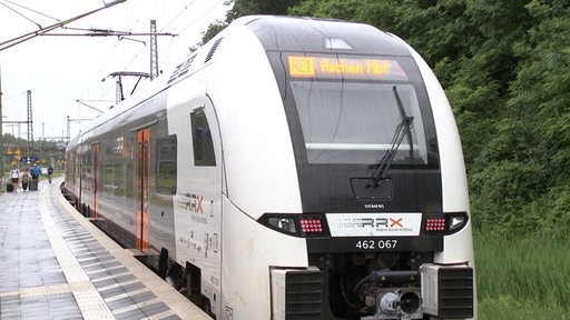 Ein Zug des Betreibers RRX mit der Anzeige Aachen Hbf steht am Bahnsteig