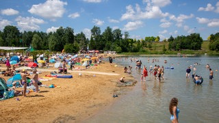 Seepark Zülpich: Badegäste im Wasser und am Sandstrand eines Badesees