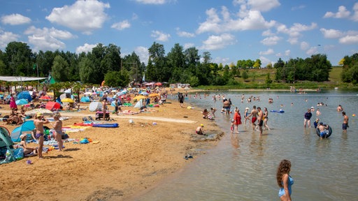 Seepark Zülpich: Badegäste im Wasser und am Sandstrand eines Badesees