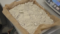 Eine Schlüssel mit weißem, bröckigem Pulver vor einer Waage
