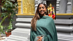 Bemini Nagulendran steht im Tempel vor einem Schrein.