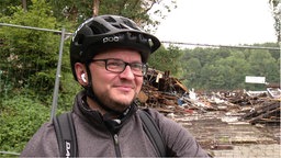 Ein Mann steht vor der Brandruine der Zornigen Ameise