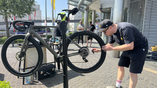 Ein Mann kontrolliert etwas an einem Fahrrad