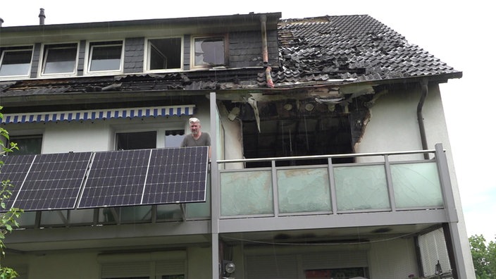 Von dem Brand zerstörte Wohnung und Anwohner Elmar Sontowski auf einem Balkon