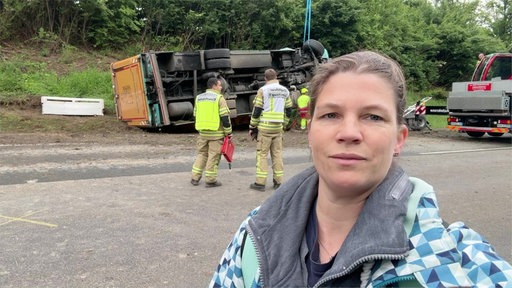 WDR Reporterin Gerlinde Spratte vor dem umgekippten LKW