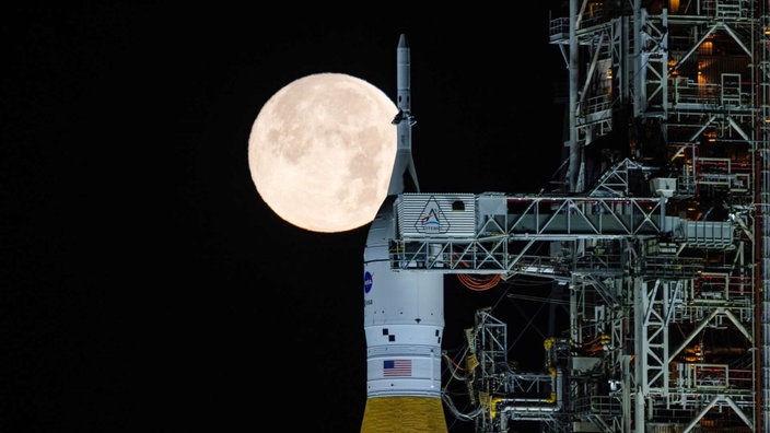 Die Artermis-2-Rakete vor einem Vollmond.