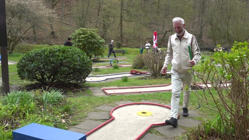 Ein Besucher spielt Minigolf