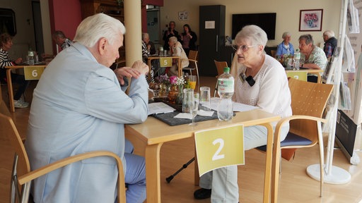 Zwei Senioren unterhalten sich beim Speed Dating