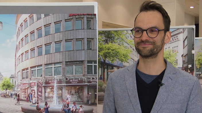Jonas Reimann trägt Brille und ein graues Jackett