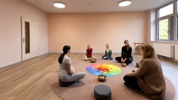 Therapeutin mit Kindern im Therapieraum nach dem neuen Farbkonzept