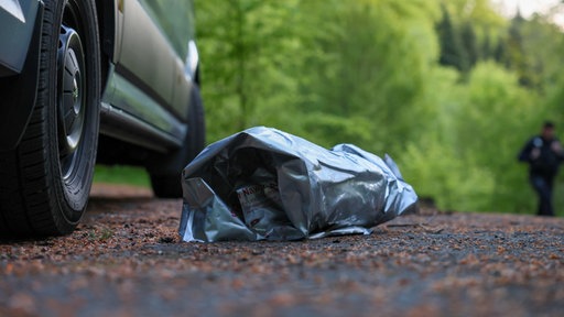 Eine Plastiktüte auf Waldboden