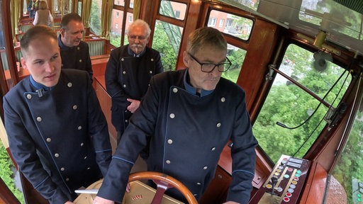 Vier Peronen im Führerstand des Kaiserwagens