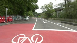 Eine leere Straße, vorne ein großer roter Bereich mit einem Fahrradsymbol