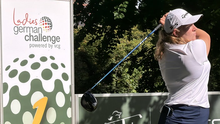 Hanna Tauberbei beim Golfschlag vor einem Banner mit Beschriftung "ladies german challange powered by vcg"