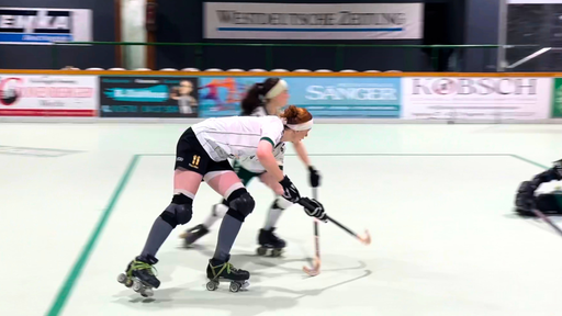 Eine Spielerin des RSC Cronenberg fährt auf Rollschuhen auf das Tor zu. In ihrer Hand ist ein Hockeyschläger.