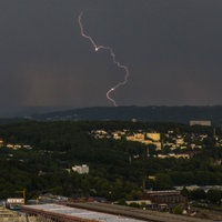 Eine Panoramaaufnahme zeigt einen Blitz am dunklen Himmel über Wuppertal