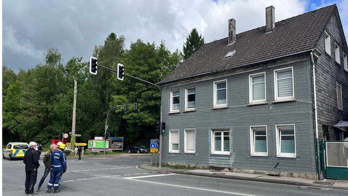 Ein graues Wohnhaus an einer Straße.