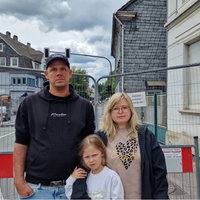 Familie Ils mit Kind, guckt traurig in die Kamera