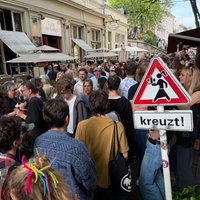 Volle Straße beim Luisenfest in Wuppertal. Im Vordergrund ein Verkehrsschild, das auf kreuzende Service-Kräfte hinweist