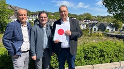 drei Männer stehen auf dem zukünftigen Friedhof