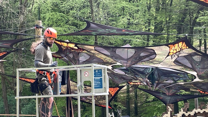 Mitarbeiter befestigt Sonnenschirme