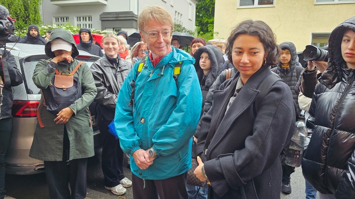 Philip Daltrop aus England, mit Frau und Tochter steht in einer Gruppe von Menschen