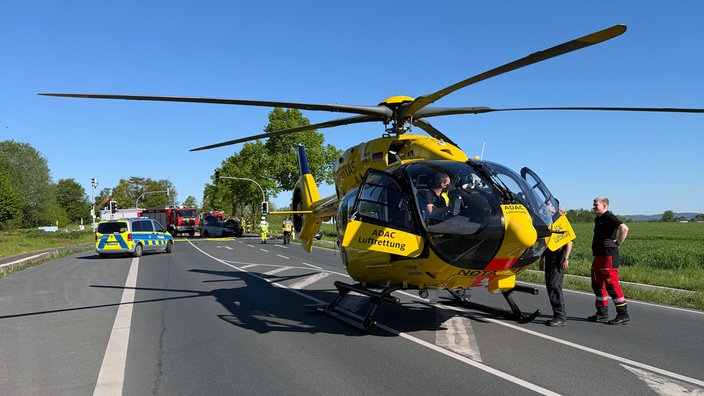 Ein Rettungshelikopter steht auf der Straße unweit der Unfallstelle.