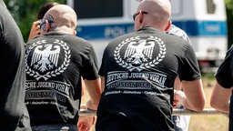 Zwei Männer tragen T-Shirts der rechtsextremen Gruppe "Deutsche Jugend Voran"