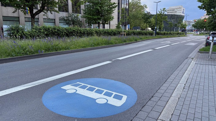 Eine mehrspurige Straße, auf der rechten Spur ist ein großes Symbol mit einem Bus
