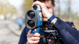 Ein Polizist blickt durch eine Laserpistole