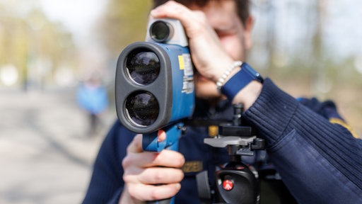 Ein Polizist blickt durch eine Laserpistole