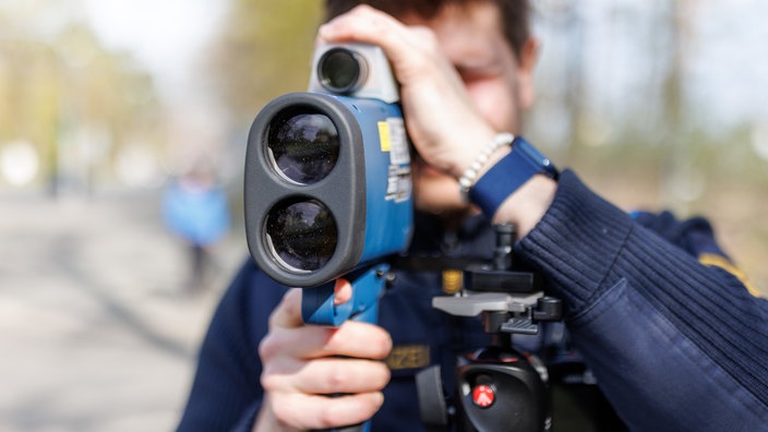 Ein Polizist blickt durch eine Laserpistole