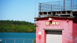 Der rot gestrichene Turm mit DLRG-Schriftzug direkt am See