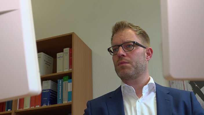 Richter Christoph Kuznik blickt konzentriert auf einen PC-Bildschirm.