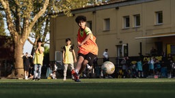 Kind spielt Fußball.