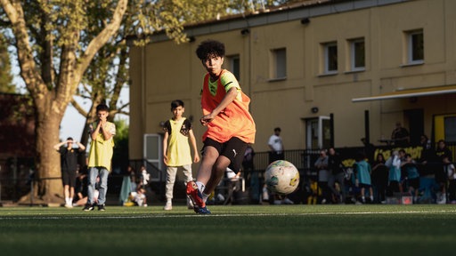 Kind spielt Fußball.