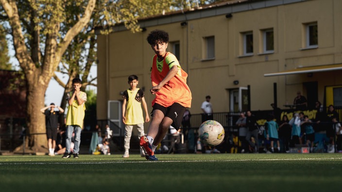 Kind spielt Fußball.