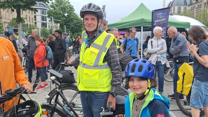 Ein älterer Mann und sein Enkel stehen neben ihren Fahrräder