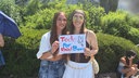 Zwei junge Frauen halten ein Schild hoch, auf dem steht: "Todo por Bad Bunny".