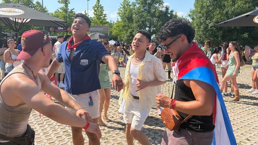 Vier Männer tanzen ausgelassen.