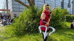 Eine Frau im Cosplay von Charlie Morgenstern aus der Serie Hazbin Hotel.