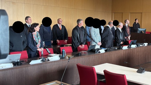 Die Angeklagten im Drogenprozess stehen neben ihren Strafverteidigern.