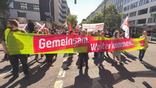 Demo Teilnehmer halten ein Banner von verdi