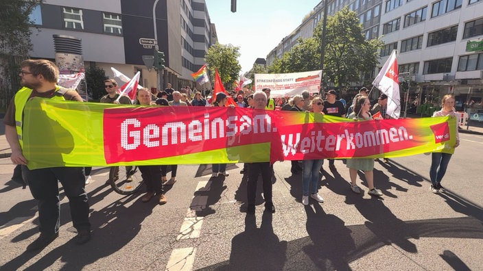 Demo Teilnehmer halten ein Banner von verdi